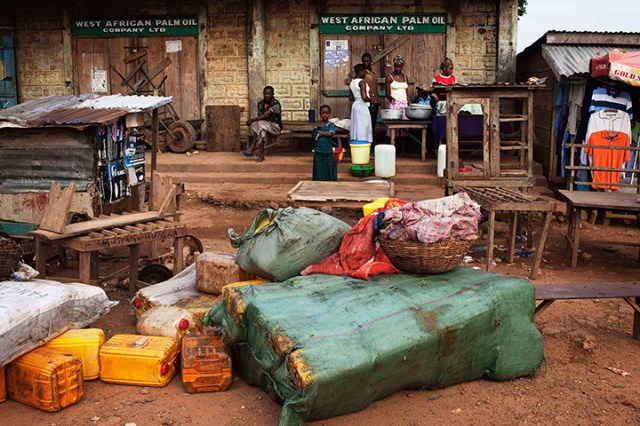 Containers of palm oil lie in front of a store in the town of Kailahun