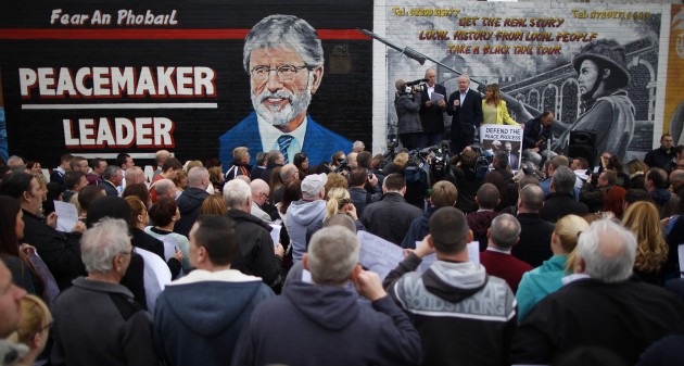 Republican demonstrators gather at a mural depicting and praising Adams's role in the peace process (Photo: AP)
