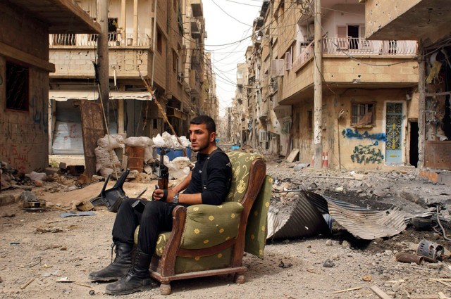 A member of the Free Syrian Army sits amidst rubble in Deir al-xor (Photo: Khalil Ashawi / Reuters)