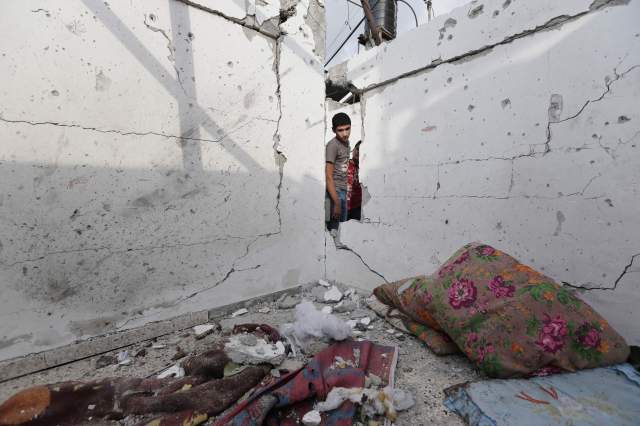 A young Palestinian examines damages to house in the Jebaliya refugee camp that had been hit by an Israeli strike. (The Associated Press)