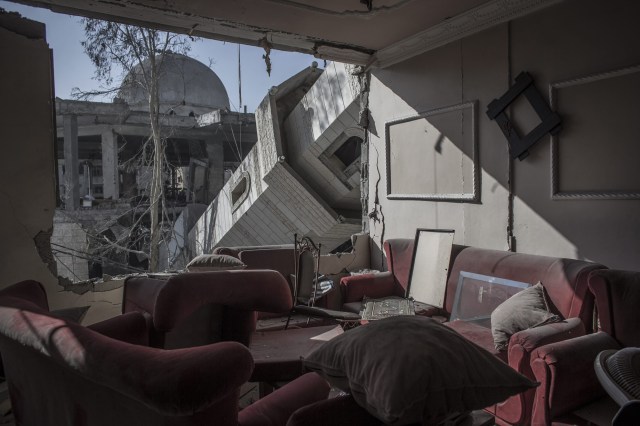 A collapsed minaret rests against the exterior of an apartment block in Gaza City (Photo: Oliver Weiken / EPA