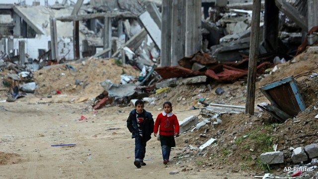 Children walk along a street in a heavily damaged neighbourhood in Gaza (Photo: AP)
