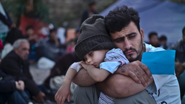 A Syrian man holds his son at a refugee camp (Photo: Muhammed Muheisen / Associated Press