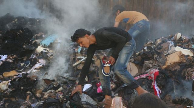 Citizens of Aleppo salvage goods from an aid convoy that had recently been bombed. (Photo: Reuters)