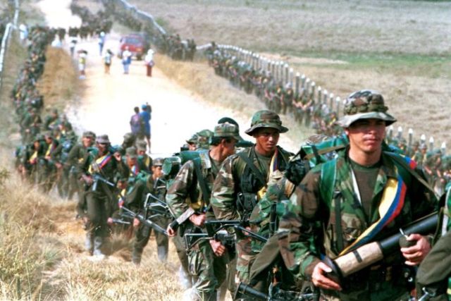 FARC troops patrol a roadway near to San Vicente de Caguan, in 1999. (Photo: Reuters)